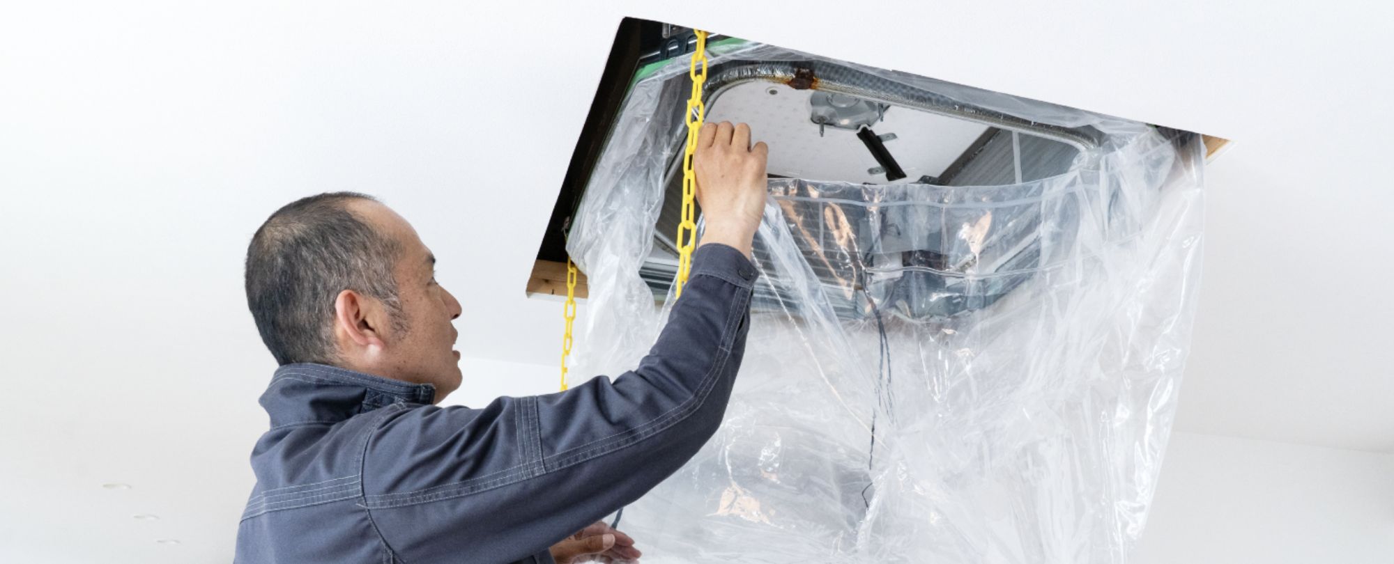 エアコンを保護する男性