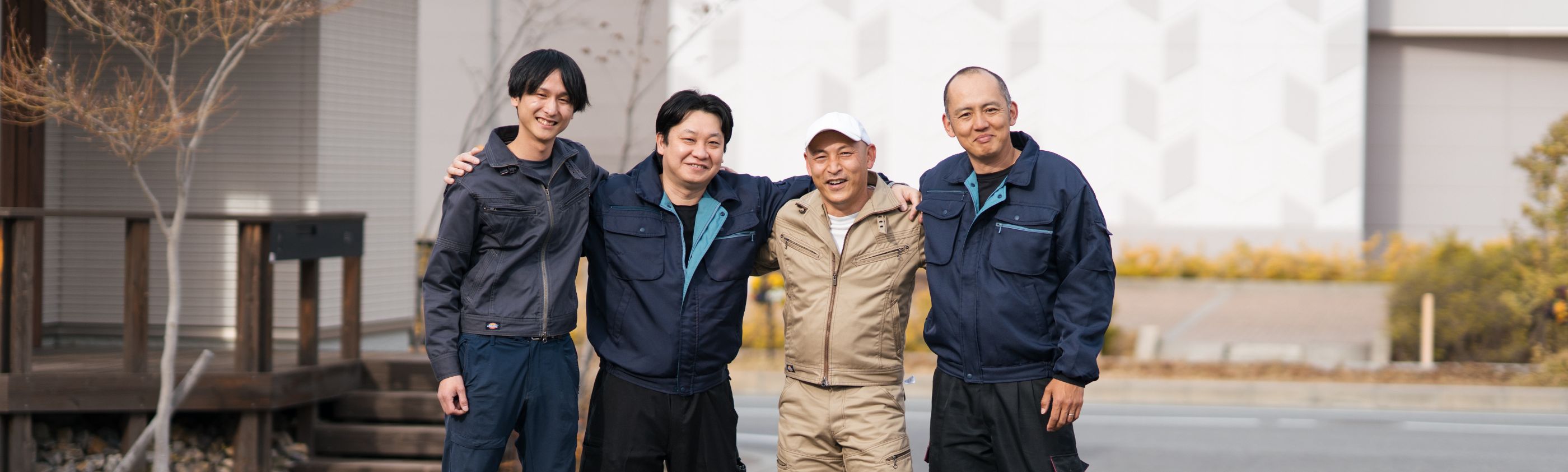 仲良く方を組む、4名の男性作業員