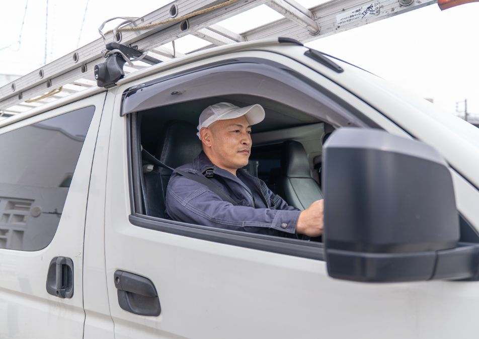 車で現地に向かう男性作業員