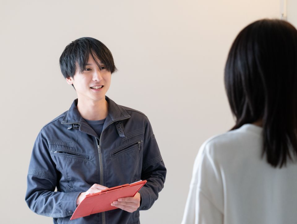 お客さんに笑顔で説明する男性作業員